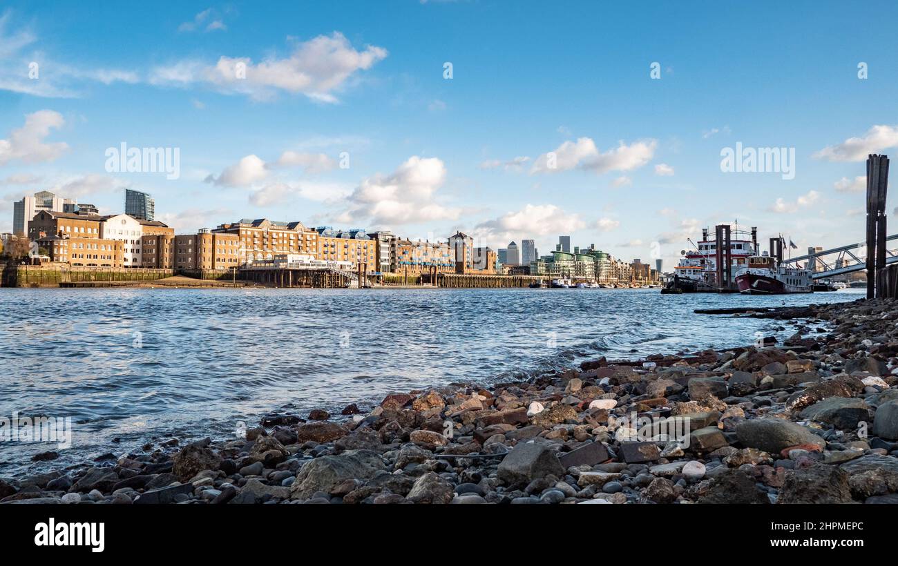 Wapping docks, East London. A low tide on the River Thames looking north towards the warehouses of the former industrial area of Wapping. Stock Photo