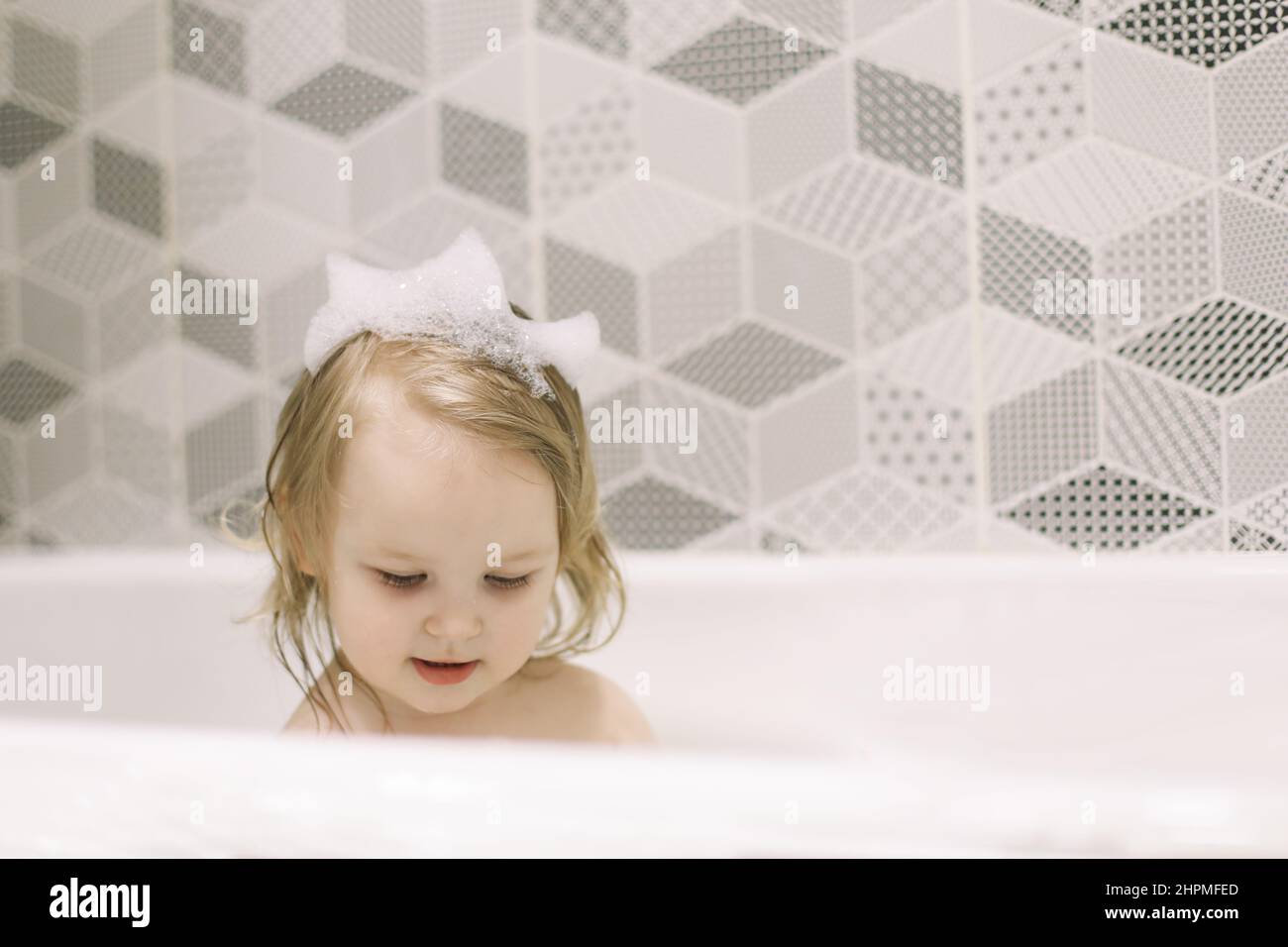 Child bathing. Little baby taking bath, closeup face portrait of