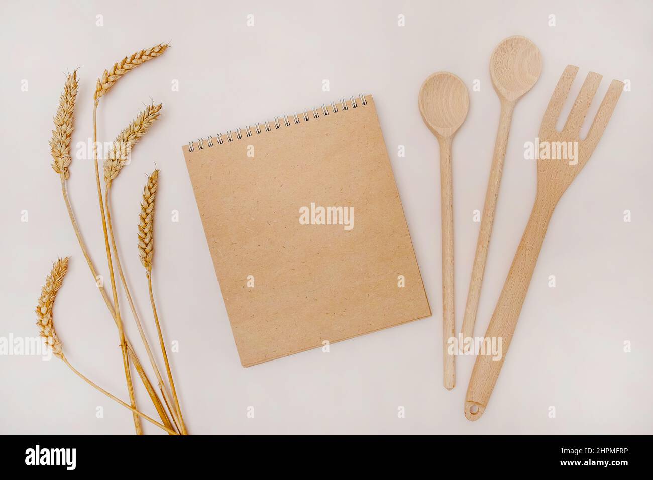 Recycled paper notepad, wooden kitchen tools and ears of wheat Stock Photo