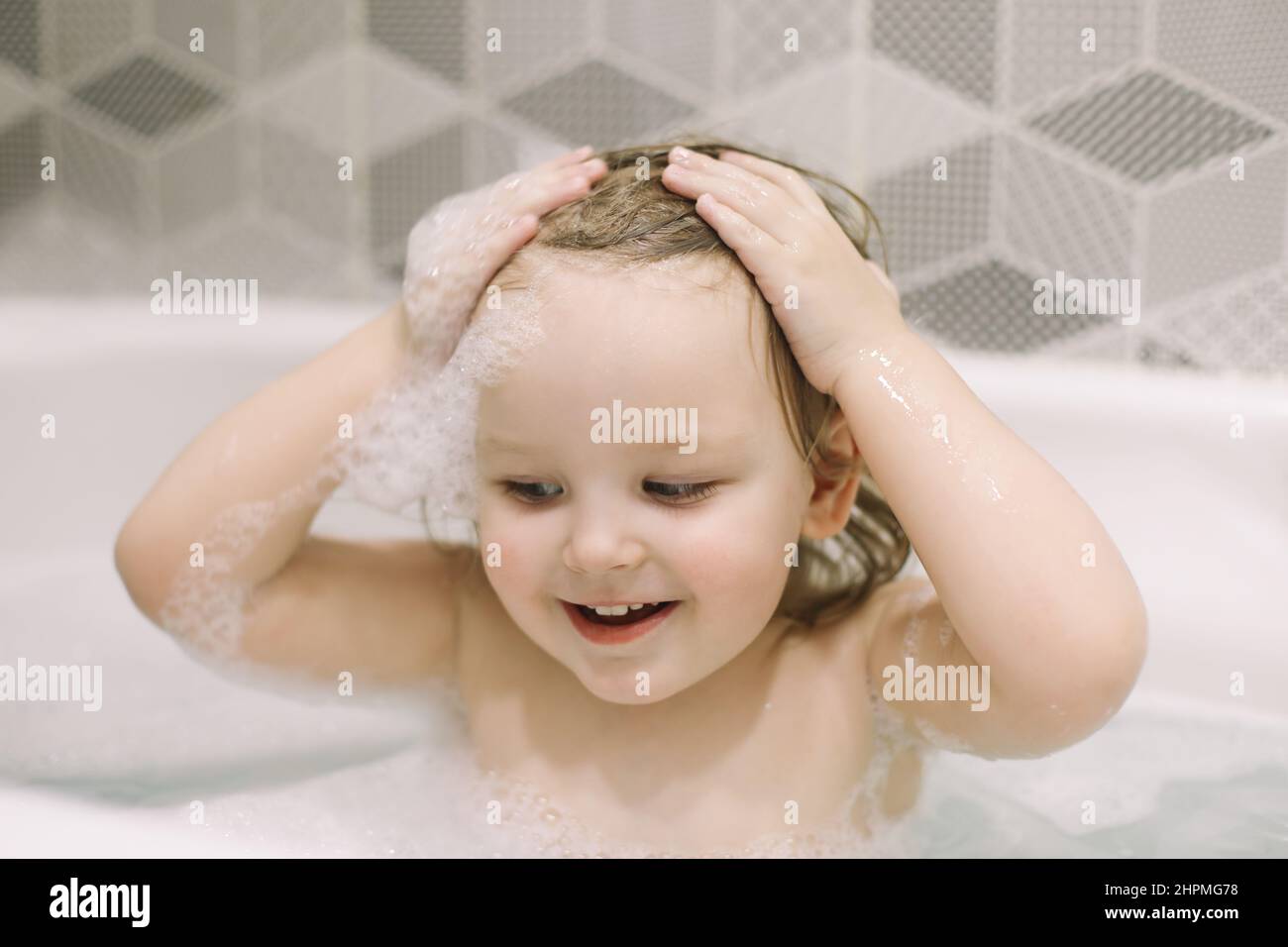 Child bathing. Little baby taking bath, closeup face portrait of
