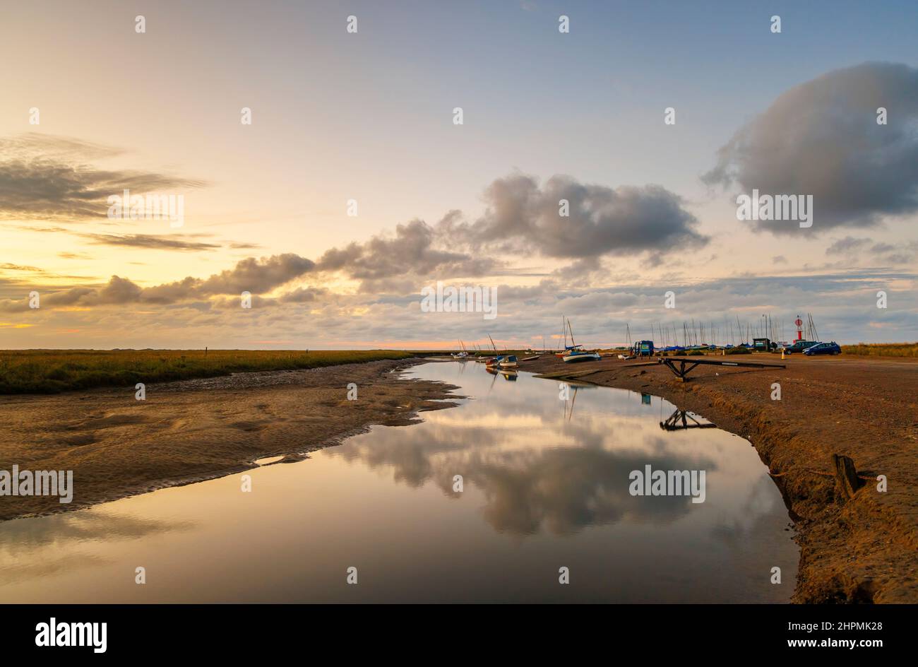 Dusk on the River Glaven estuary at low tide with boats and cloud reflections, Blakeney, a small coastal village in north coast Norfolk, England Stock Photo