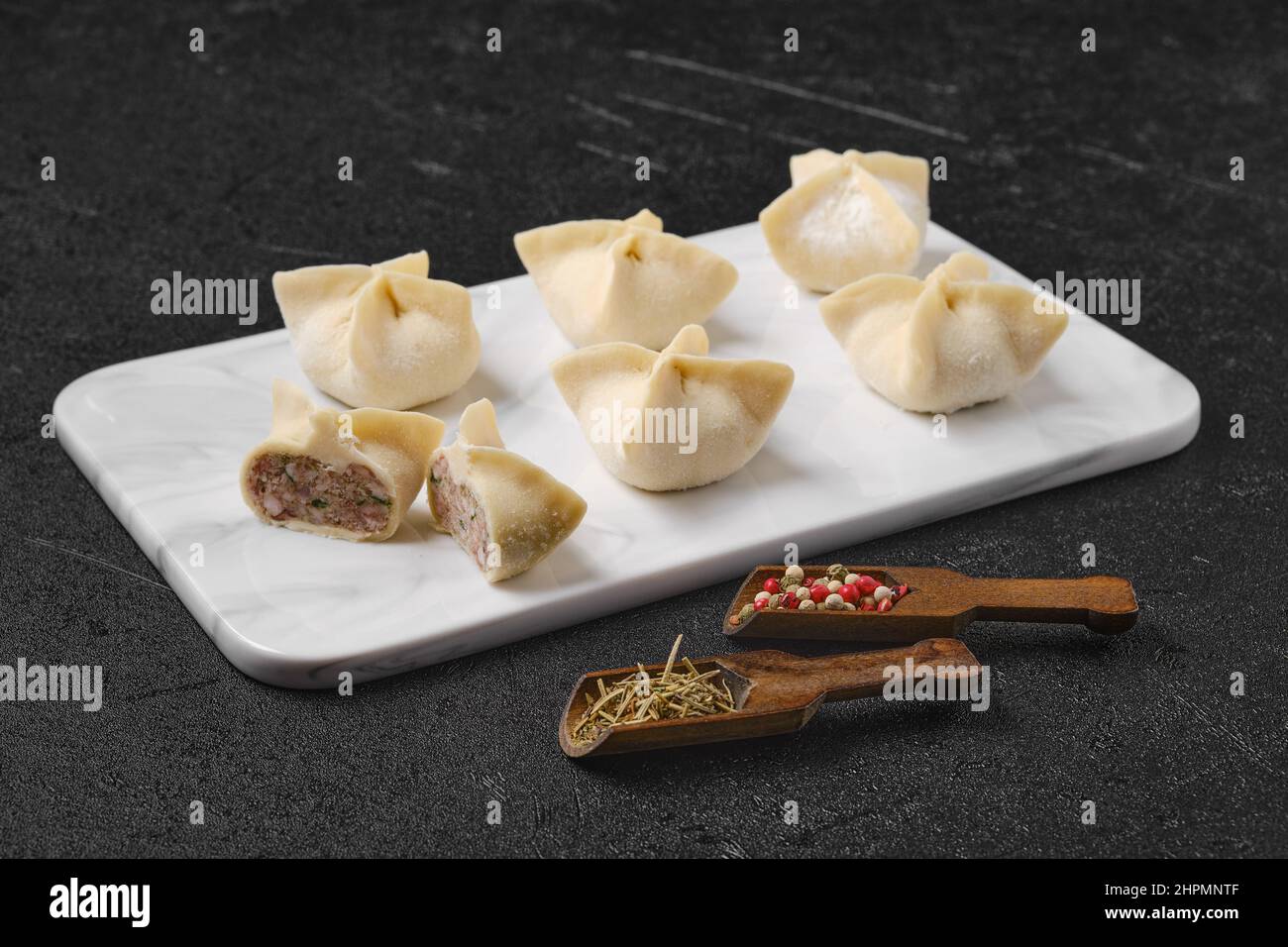 Homemade spicy beef dumplings on marble serving plate Stock Photo