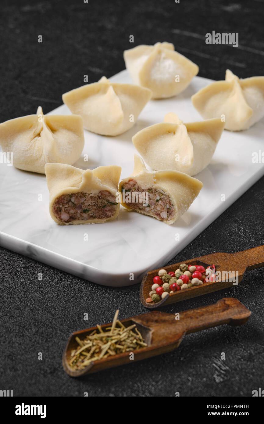 Homemade spicy beef dumplings on marble serving plate Stock Photo