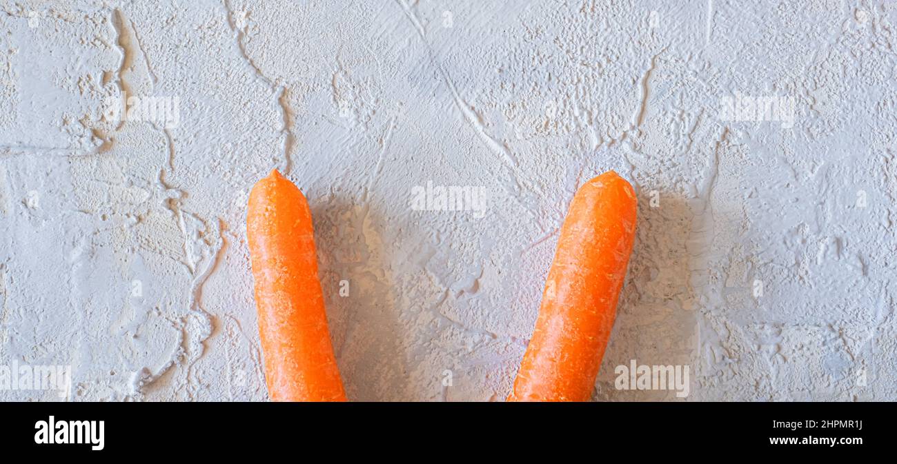 easter bunny carrot ears on light textured background. Stock Photo
