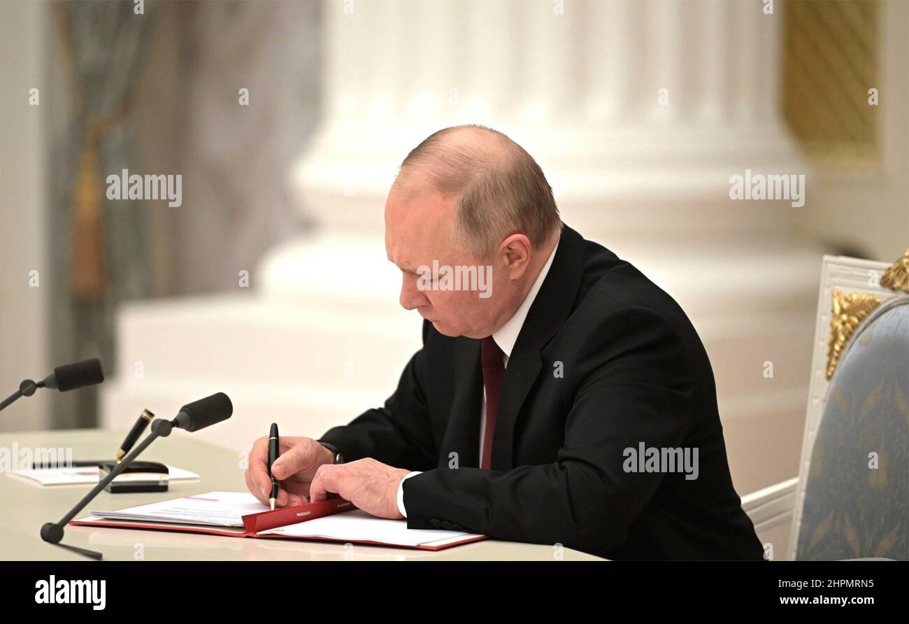 Moscow, Russia. 21st Feb, 2022. Russian President Vladimir Putin signs an executive order recognizing the separatist regions of Donetsk and Lugansk during a ceremony at the Kremlin, February 21, 2022 in Moscow, Russia. The agreement continues the push to annex Ukrainian territory into the Russian Federation. Credit: Alexei Nikolsky/Kremlin Pool/Alamy Live News Stock Photo