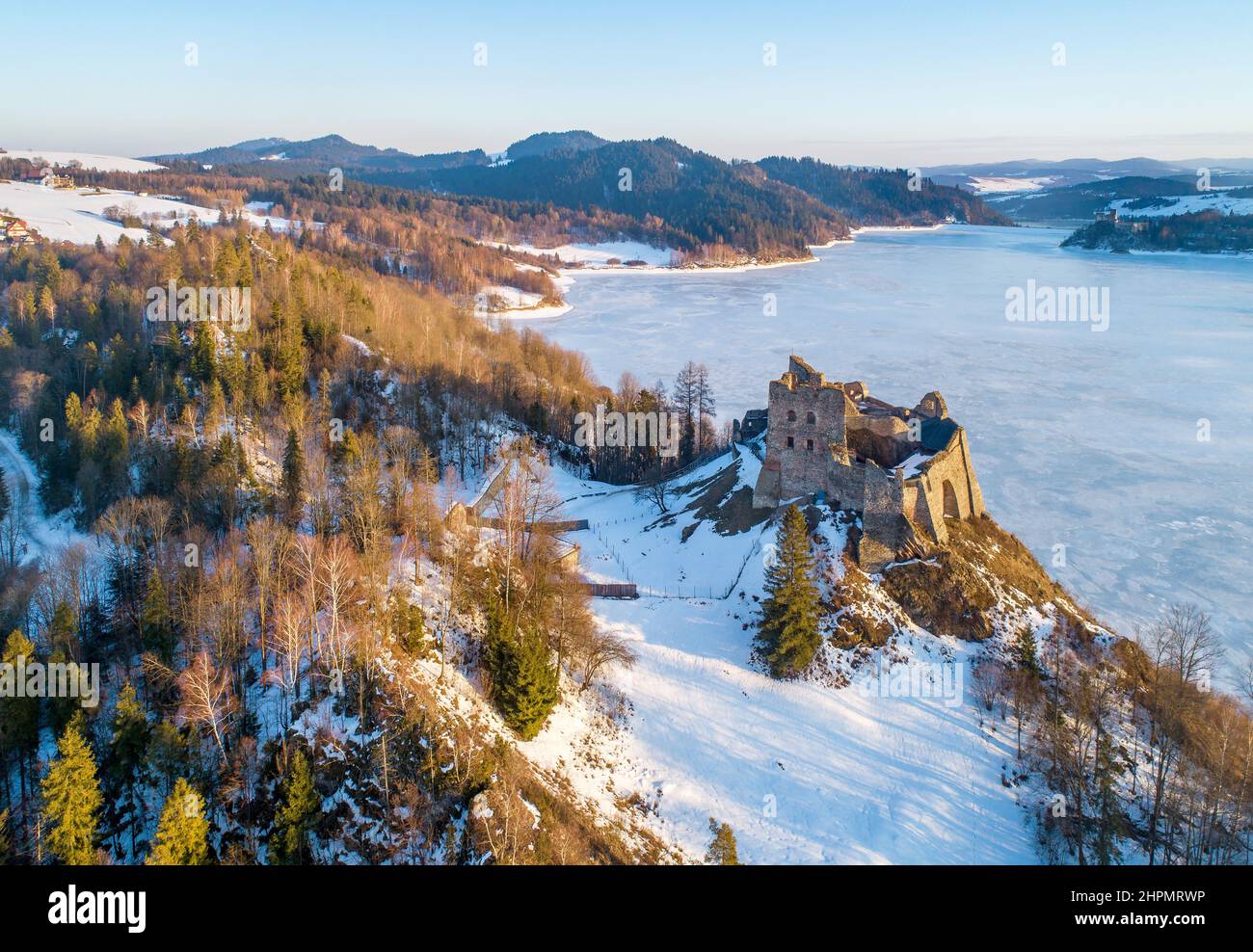 Artificial frozen Czorsztyn Lake on Dunajec River with ruins of medieval Czorsztyn castle and far view of Niedzica castle on the other side of lake Stock Photo