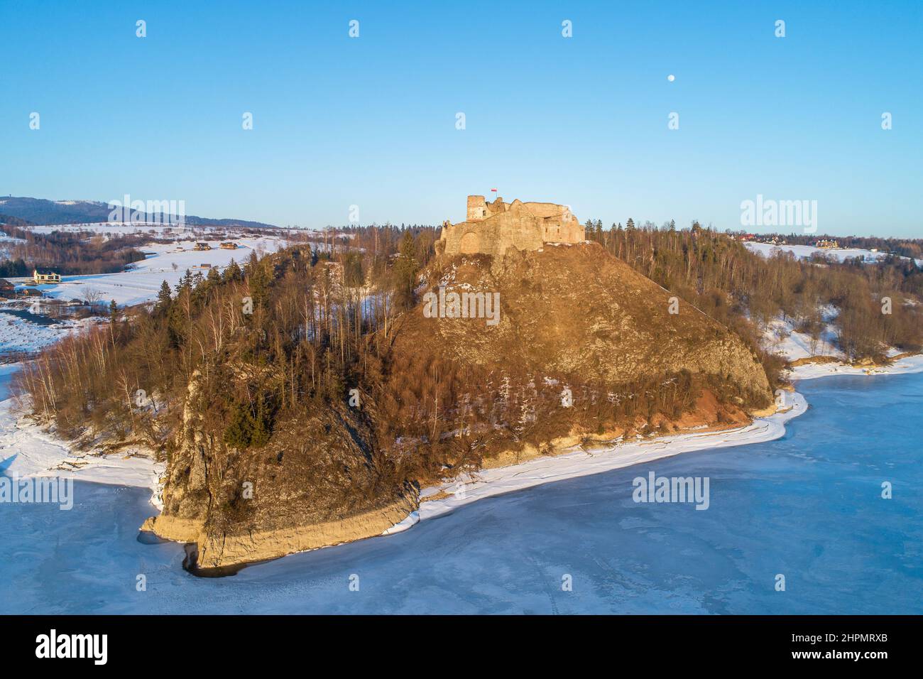 Ruins of medieval castle in Czorsztyn, Poland. Aerial view in winter in sunset light with frozen artificial Czorsztyn lake on Dunajec River and the mo Stock Photo