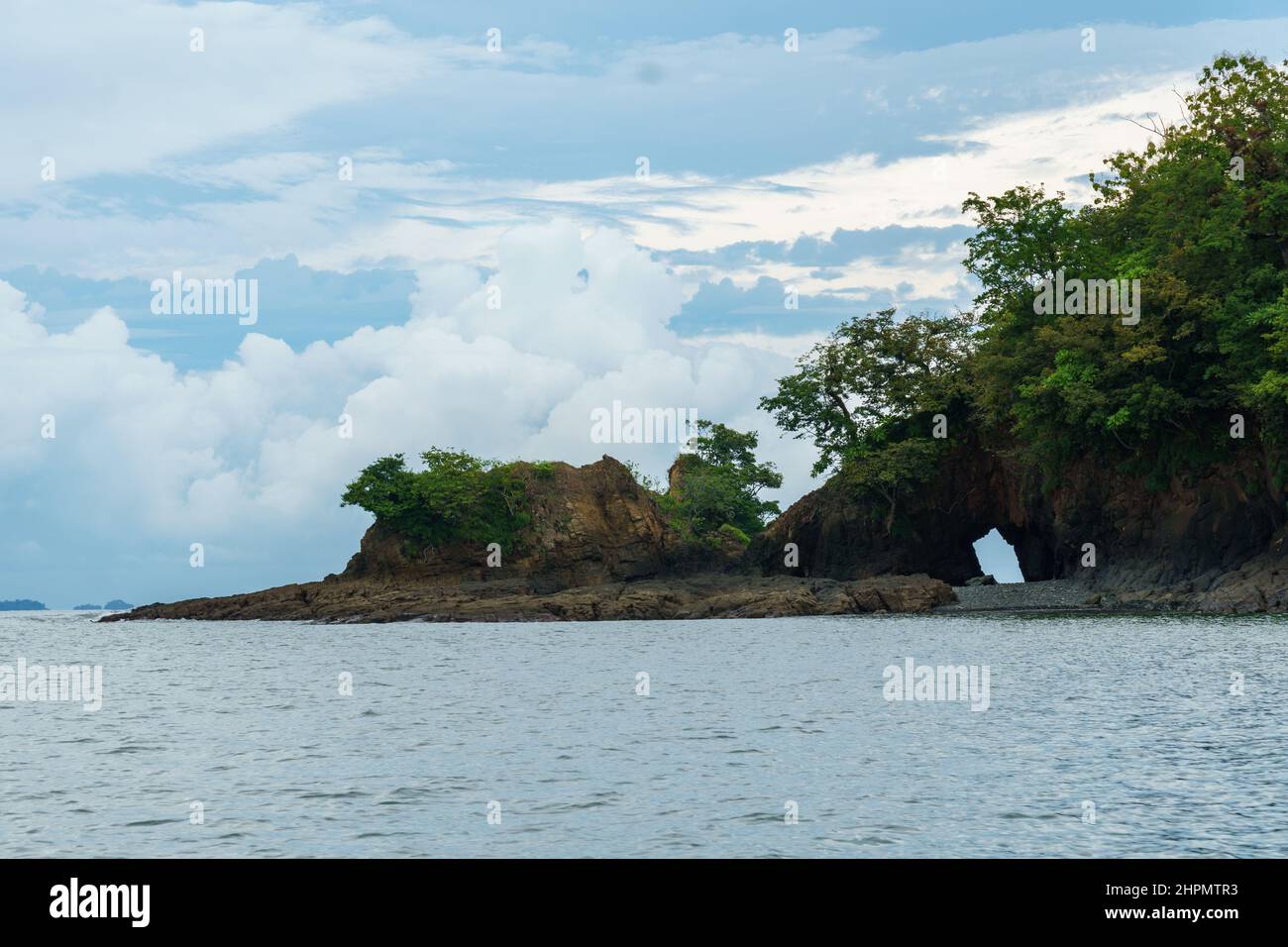 Nautual stone arch on a deserted island in Panama. Trees are growing out of the rock. Stock Photo