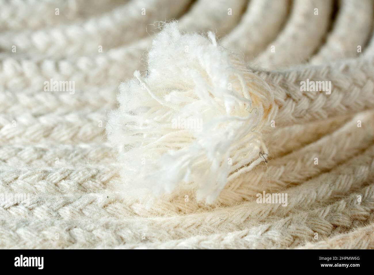Close up of the frayed end of a thin white cotton rope commonly used in