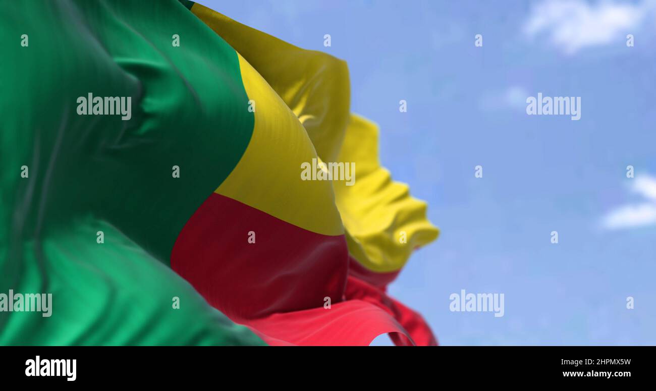 Detail of the national flag of Benin waving in the wind on a clear day. Benin is a country in West Africa. Selective focus. Stock Photo