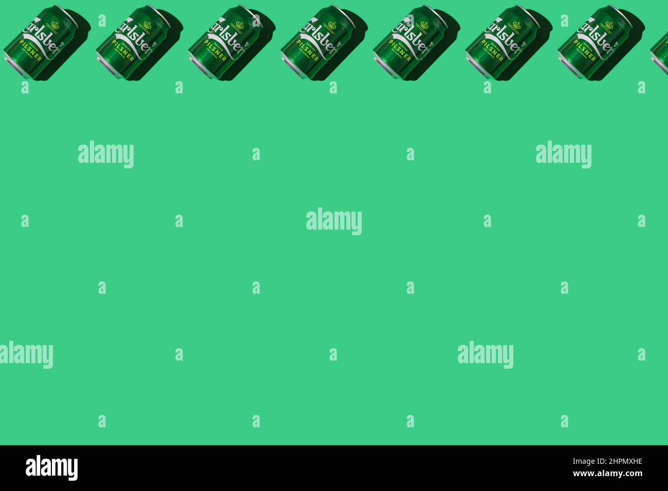 Pattern of green Heineken Dutch beer cans with hard shadow, on top, on white background. Alcohol, brewery, industry, factory and bar concept. Stock Photo