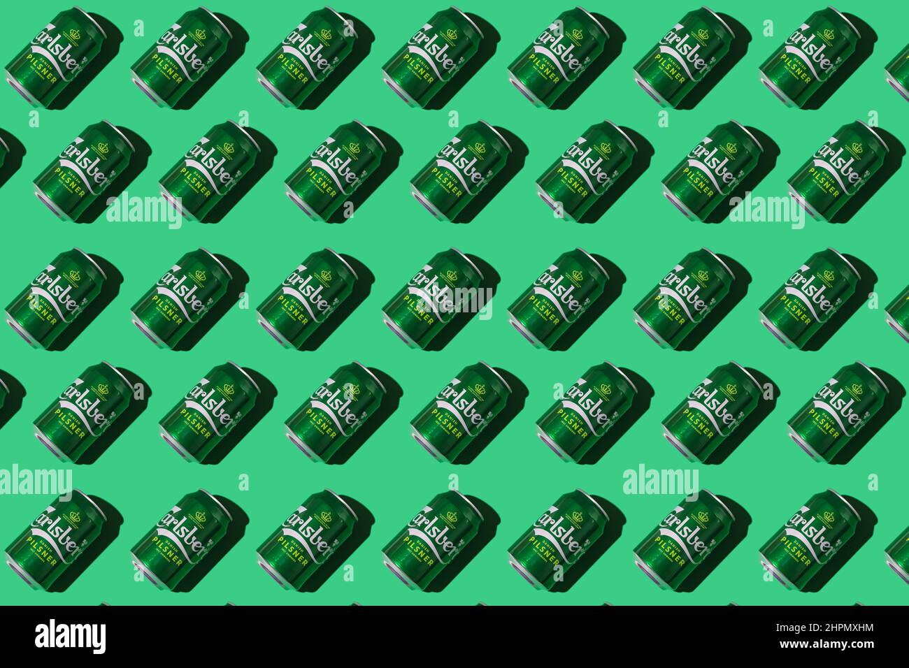 Pattern of green Heineken Dutch beer cans with hard shadow on white background. Alcohol, brewery, industry, factory and bar concept. Stock Photo