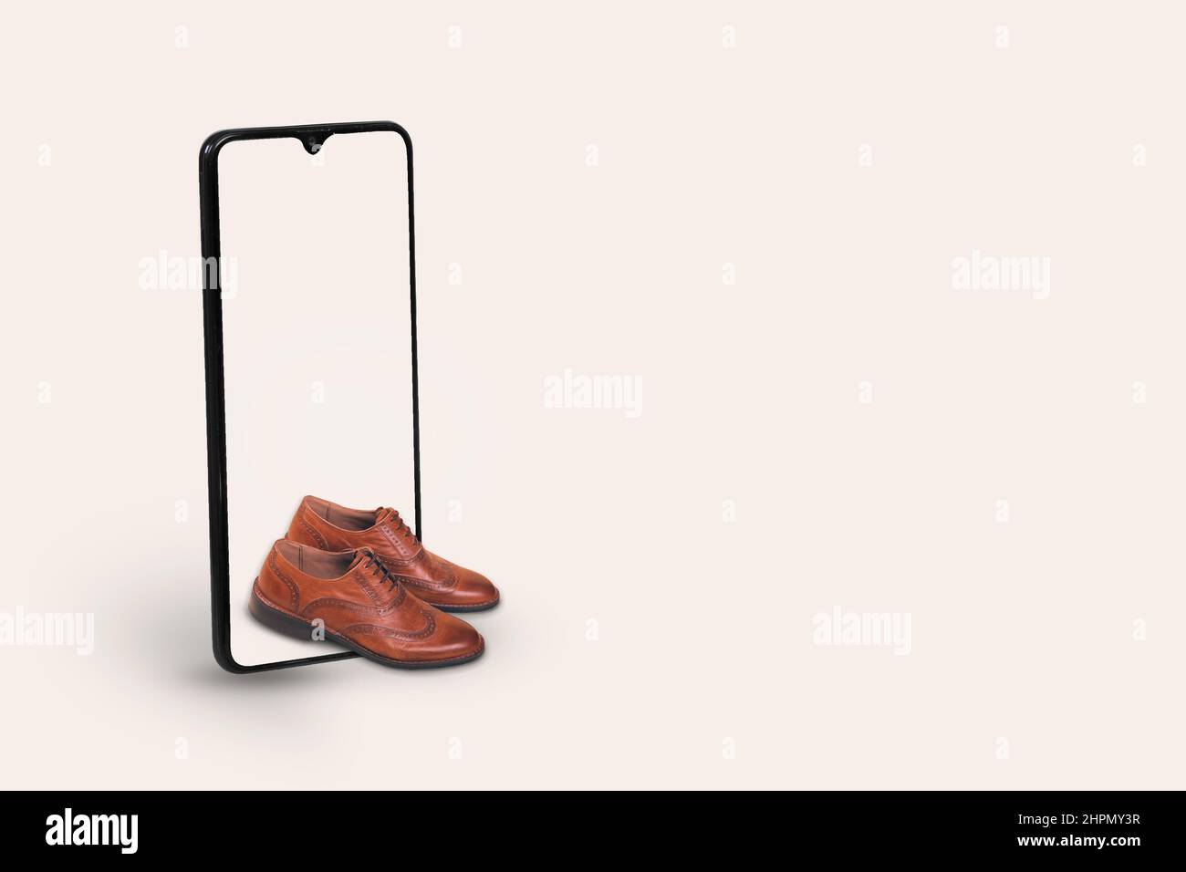 Smartphone with men's fashion leather shoes on a light gray background. Creative minimal concept of online shopping, men’s  fashion and trend.  e - co Stock Photo
