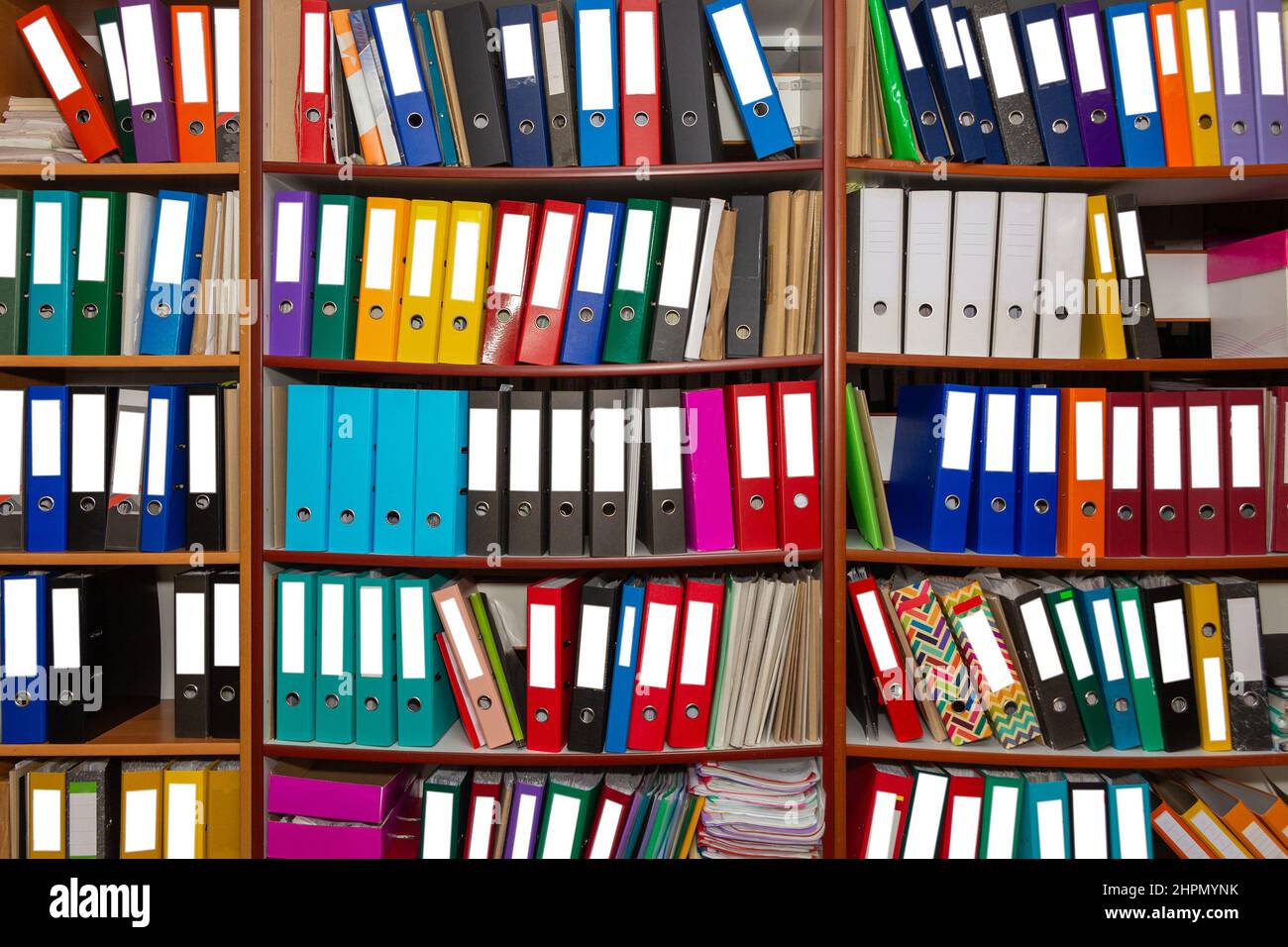 Colorful ring binder folder on wooden shelves, office stationary. A