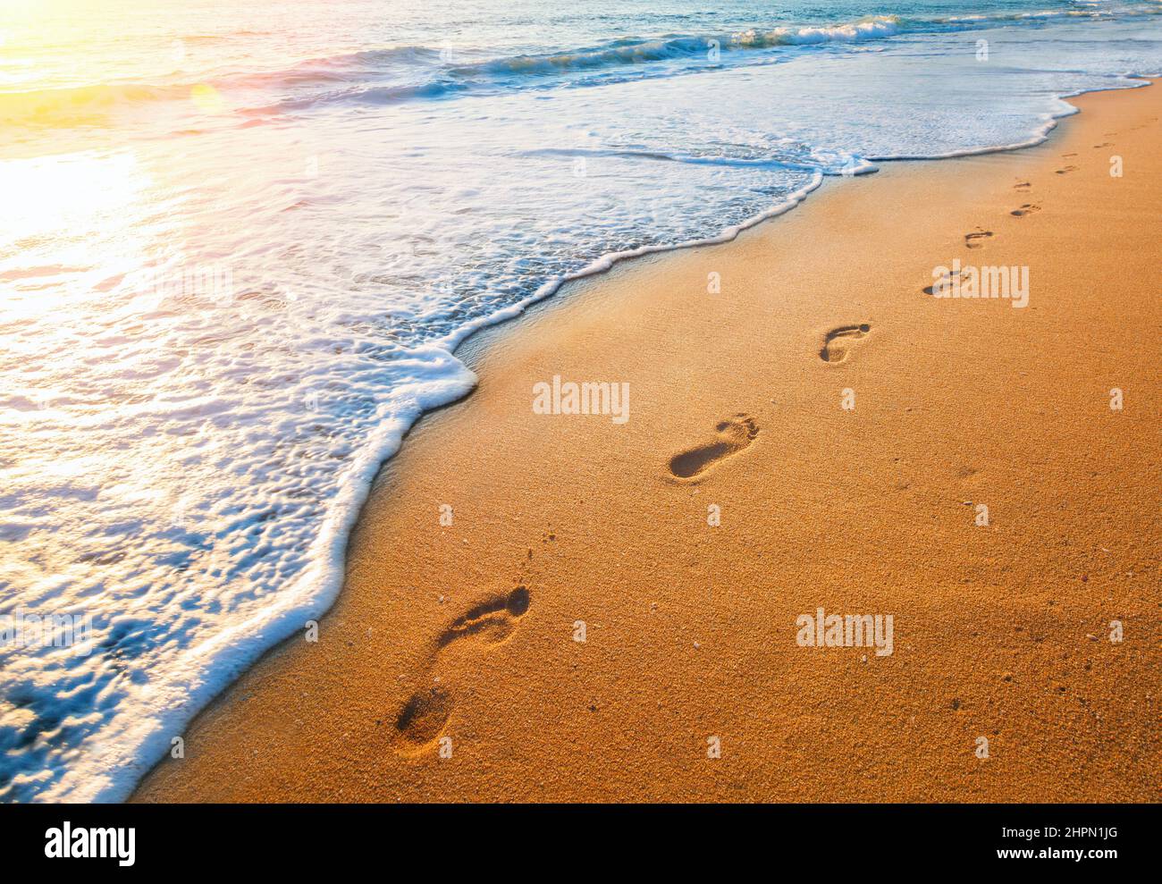 footprints on  tropical beach and beautiful  wave Stock Photo