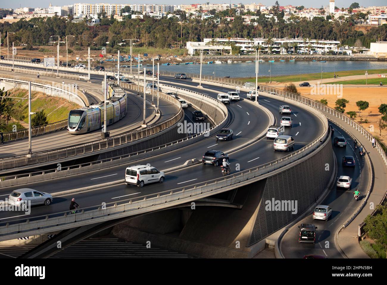Busy vehicle traffic and passenger train moves across the Hassan II bridge connecting Salé and Rabat in Morocco, North Africa. Stock Photo
