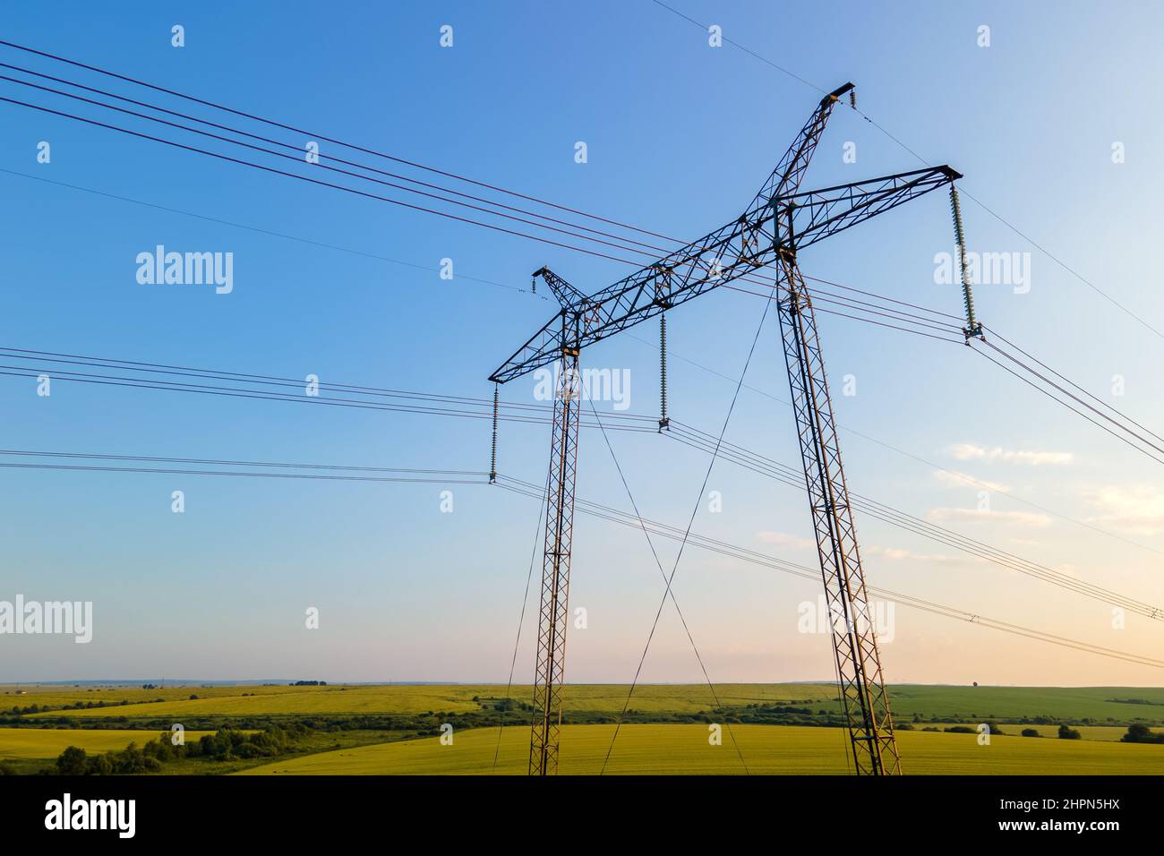 Dark silhouette of high voltage towers with electric power lines at ...