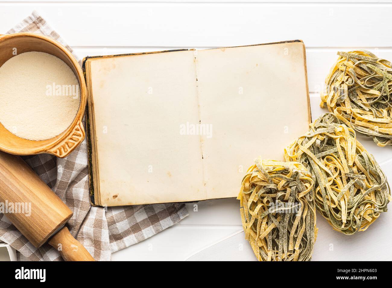 https://c8.alamy.com/comp/2HPN603/open-blank-cookbook-and-uncooked-noodles-pasta-antique-recipe-book-on-white-table-top-view-2HPN603.jpg