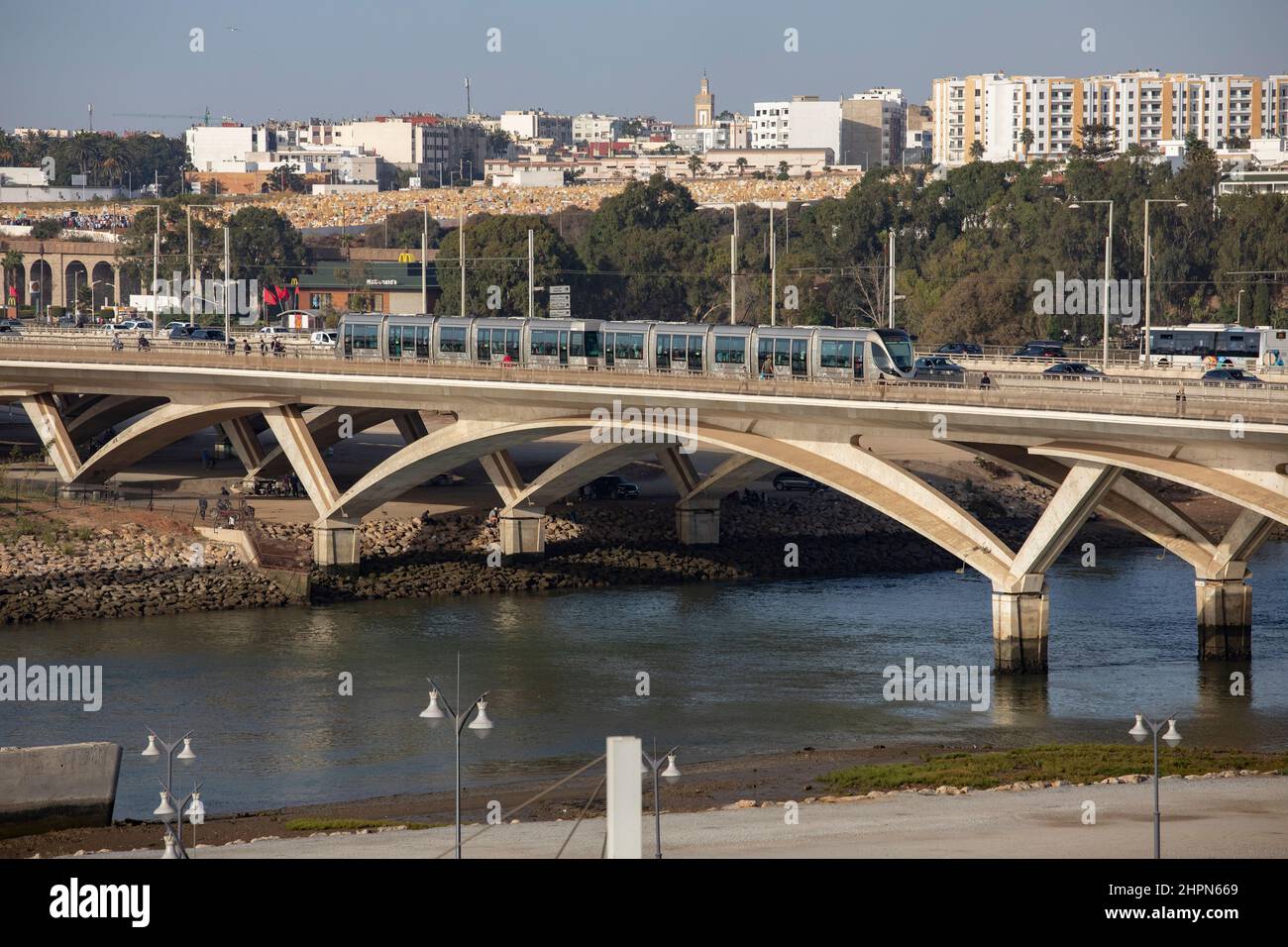 Busy vehicle traffic and passenger train moves across the Hassan II bridge connecting Salé and Rabat in Morocco, North Africa. Stock Photo