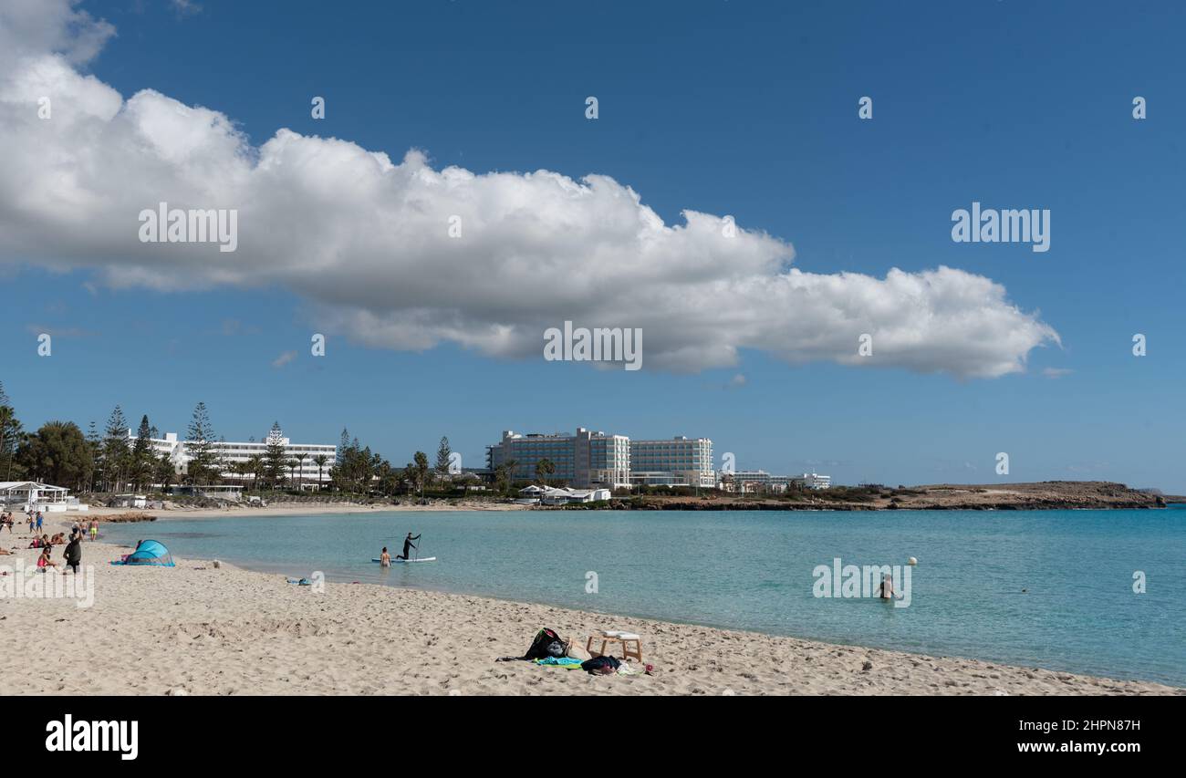 People resting and swimming in the empty beach tropical sandy beach. Nissi beach Agia Napa, Cyprus Stock Photo