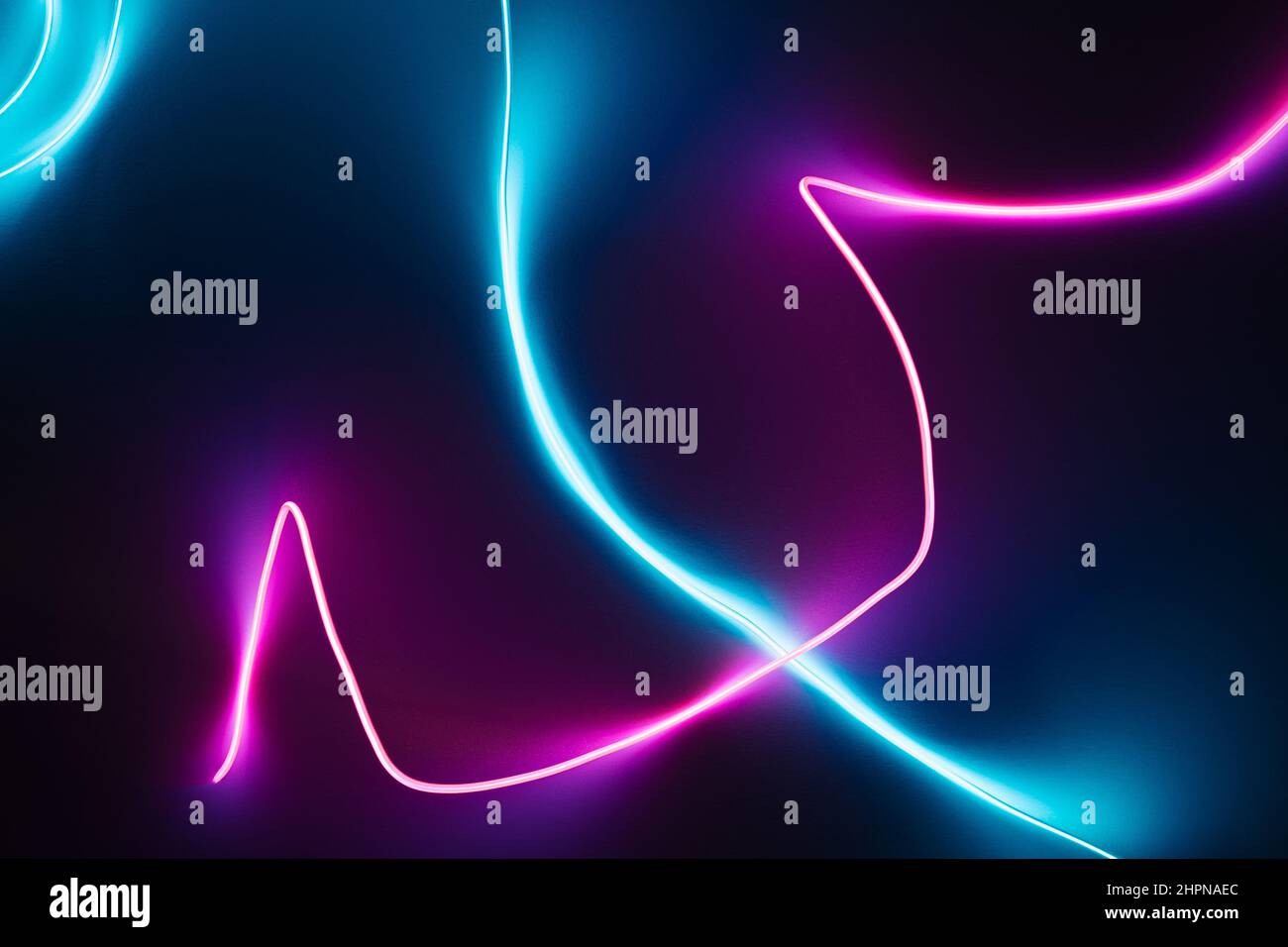 Neon blue and pink led lines on a dark night background. Cyberpunk futuristic wallpaper. Stock Photo