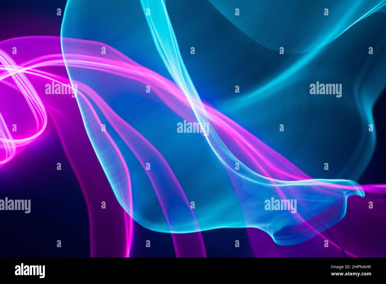 Neon blue and pink led lines on a dark night background. Vapor wave futuristic wallpaper. Stock Photo