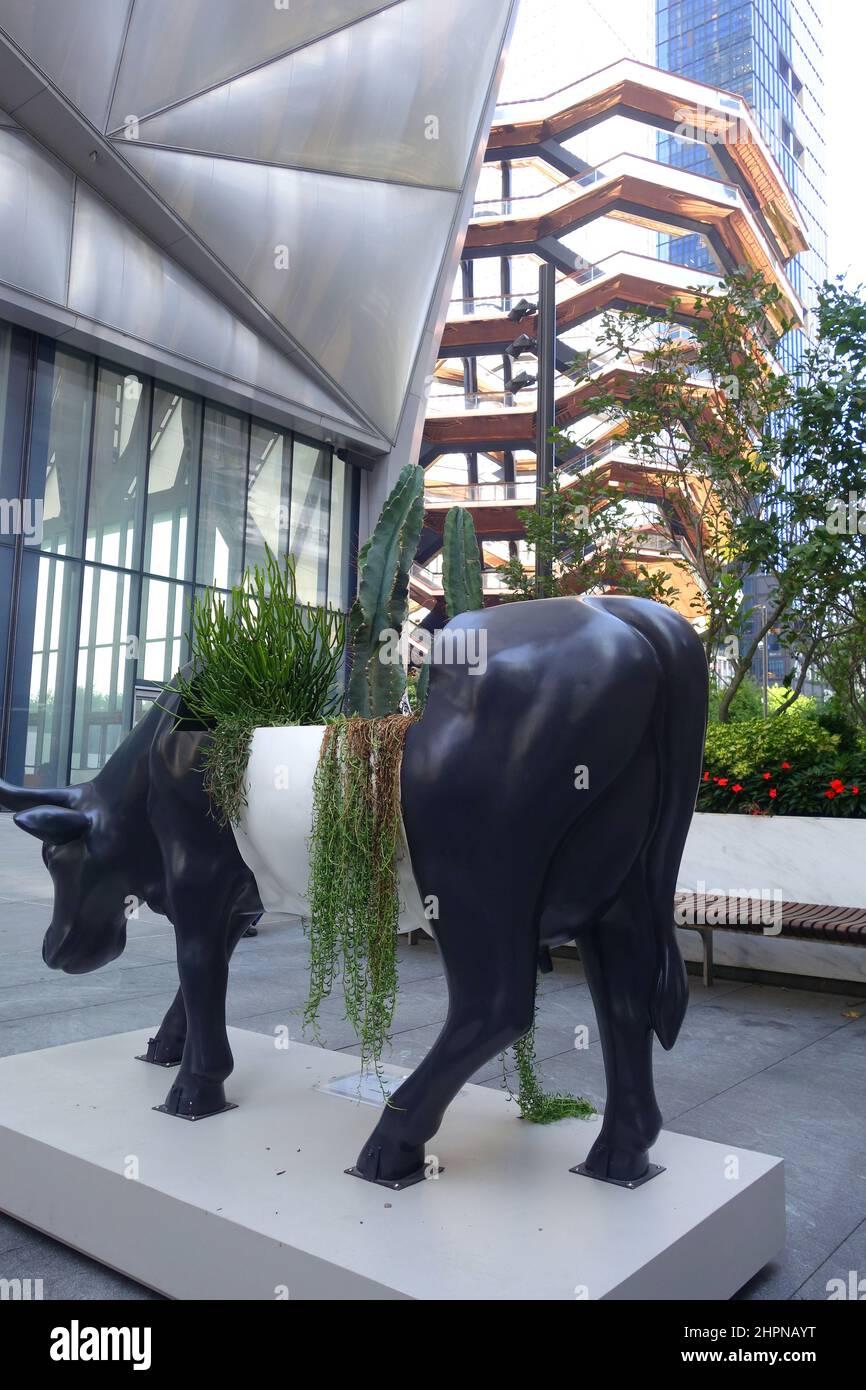 Cow Sculpture of The CowParade with The Vessel in the background at the Hudson Yards in New York City Stock Photo