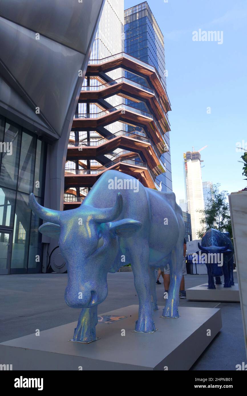 Cow Sculpture of The CowParade with The Vessel in the background at the Hudson Yards in New York City Stock Photo