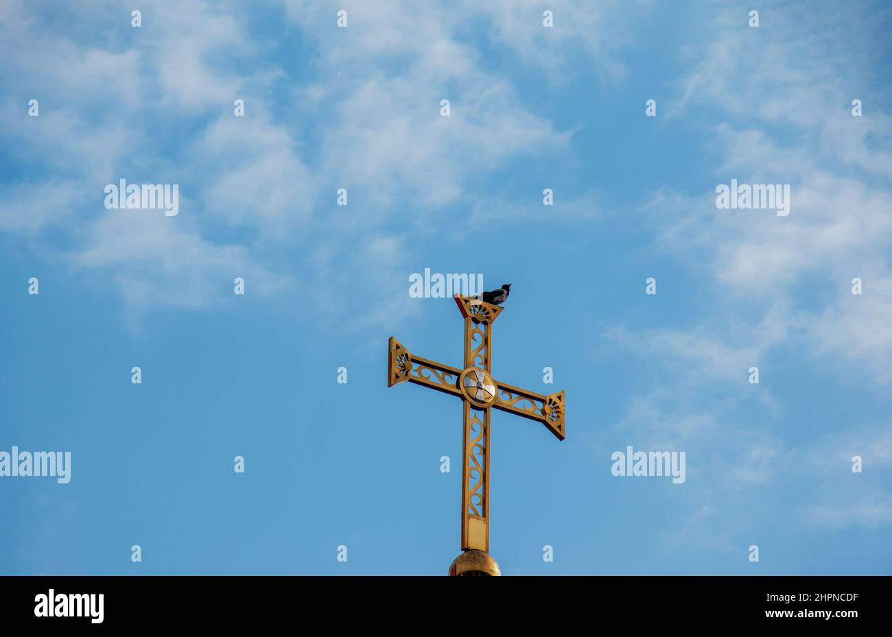 Orthodox church cross against the blue sky. A swallow sits on a cross. Easter concept. Stock Photo