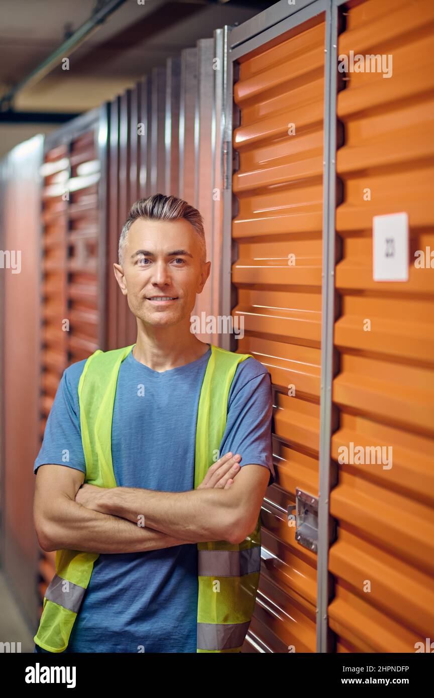 Calm worker standing alone by a cargo container Stock Photo
