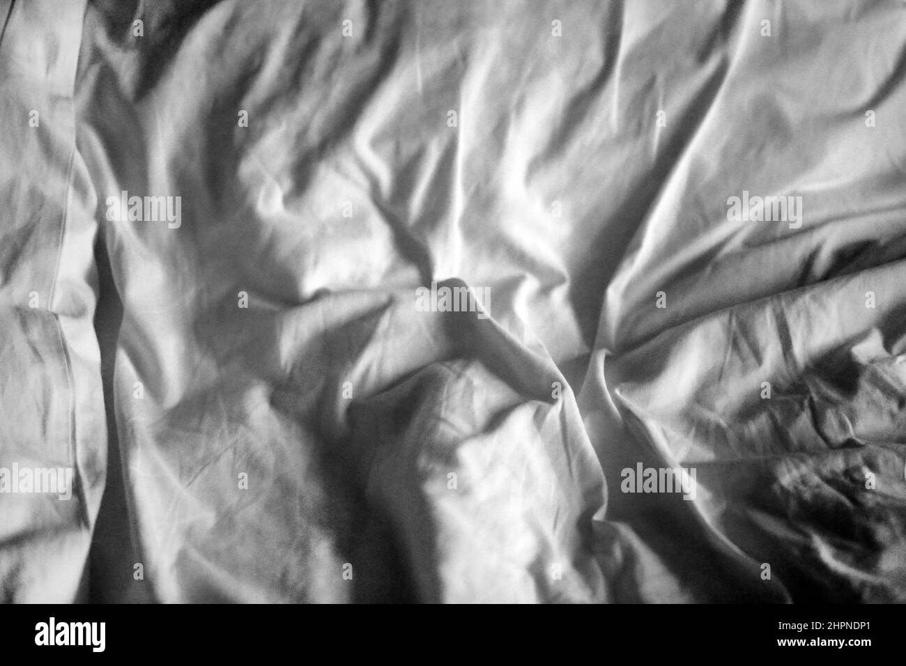 White crumpled sheet with shadows photographed close-up Stock Photo
