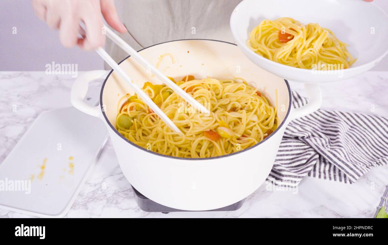 Step by step. Serving a one-pot pasta into a white pasta plate Stock