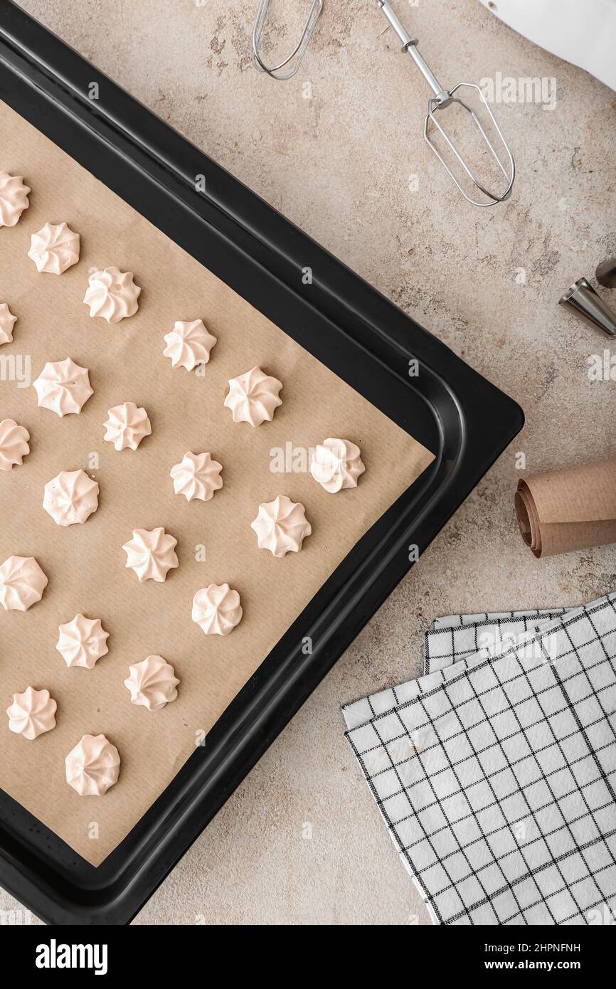 Baking sheet with sweet meringue on grunge background, closeup Stock