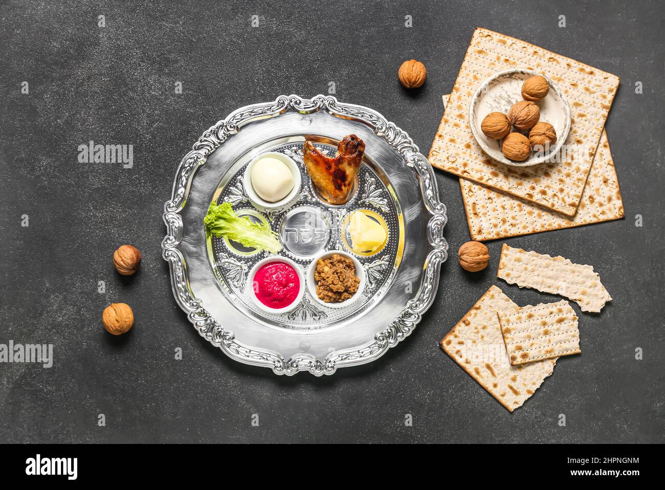 Passover Seder plate with traditional food, walnuts and matza on dark ...