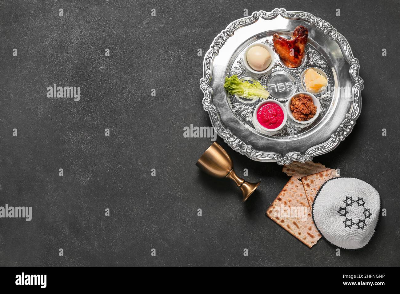 Passover Seder plate with traditional food, cup, matza and kippah on ...