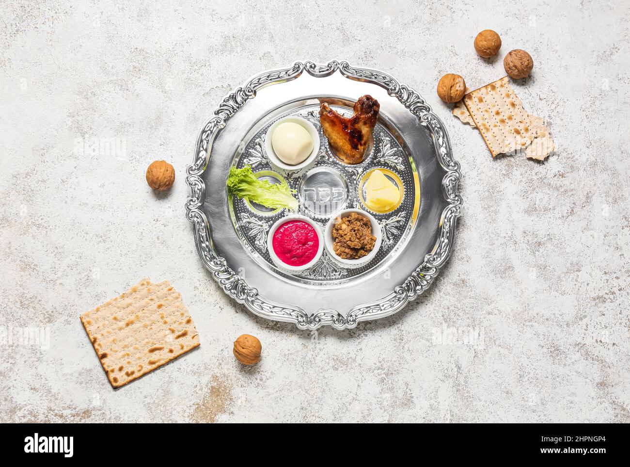 Passover Seder plate with traditional food, walnuts and matza on light ...