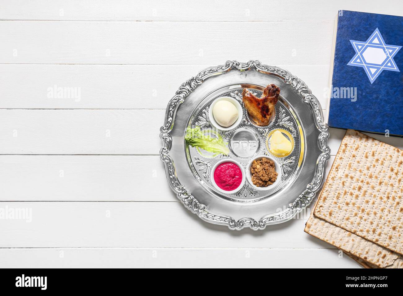 Passover Seder plate with traditional food, matza and Torah on white ...