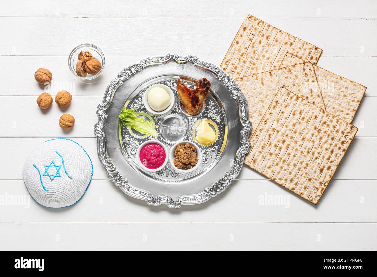 Passover Seder plate with traditional food, matza and kippah on white ...