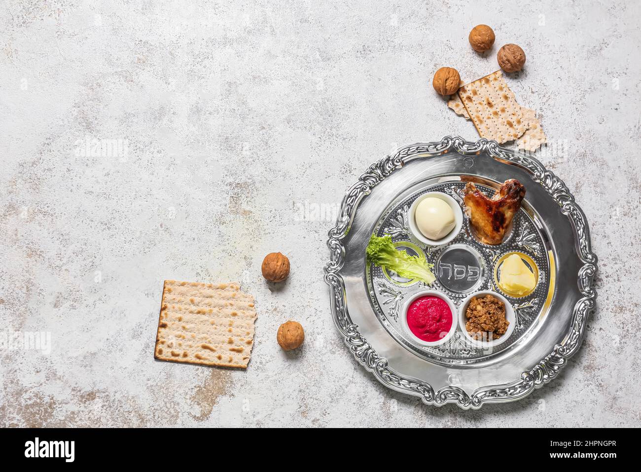 Passover Seder plate with traditional food, walnuts and matza on light ...