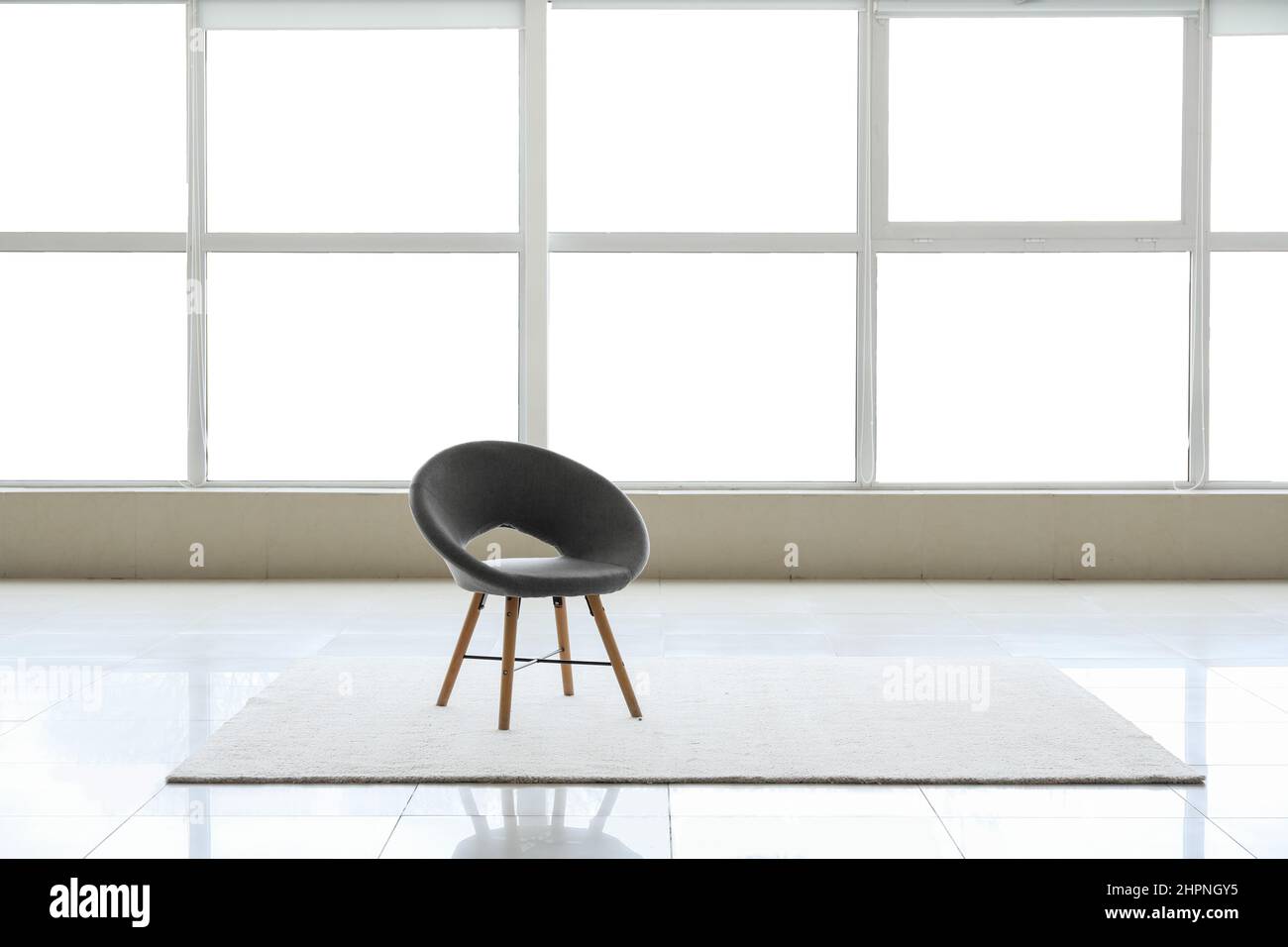 View of big empty room with windows, chair and carpet Stock Photo Alamy