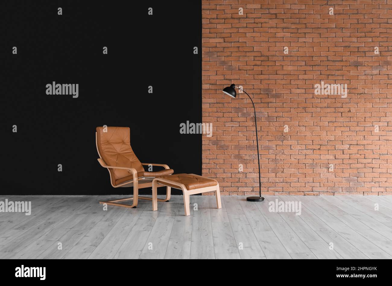 Modern armchair with ottoman and standard lamp in empty room Stock ...