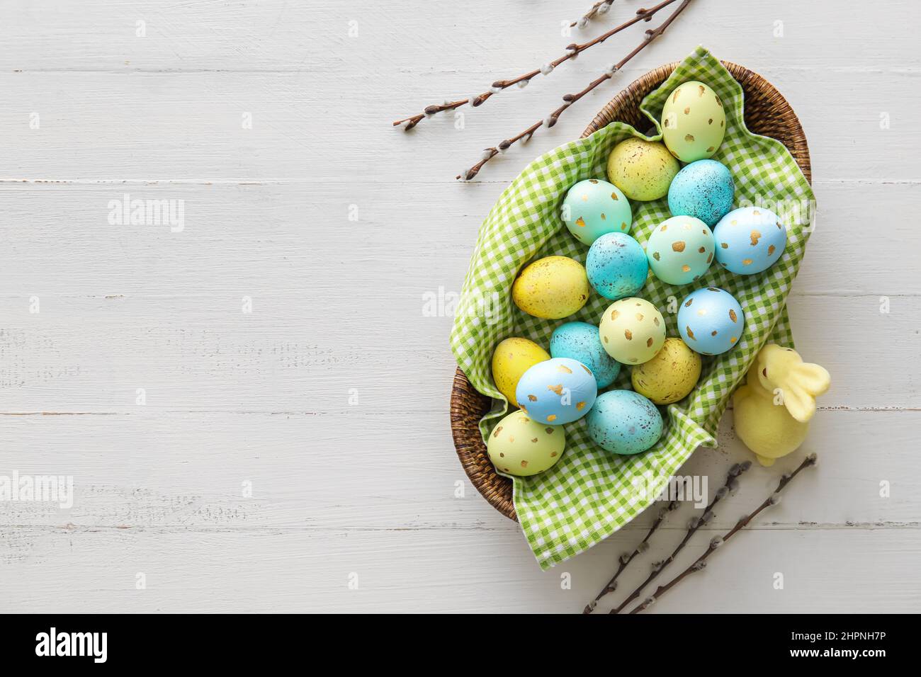Basket with painted Easter eggs, willow branches and bunny on light ...