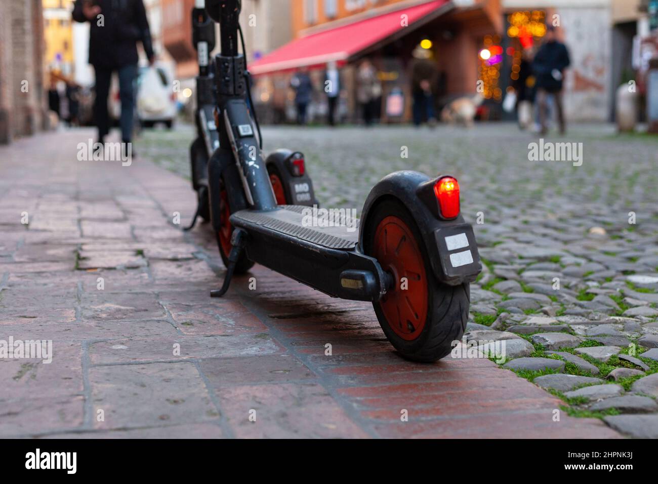 Two sharing electric scooters parked on a footpath in city center, Modena, Italy Stock Photo