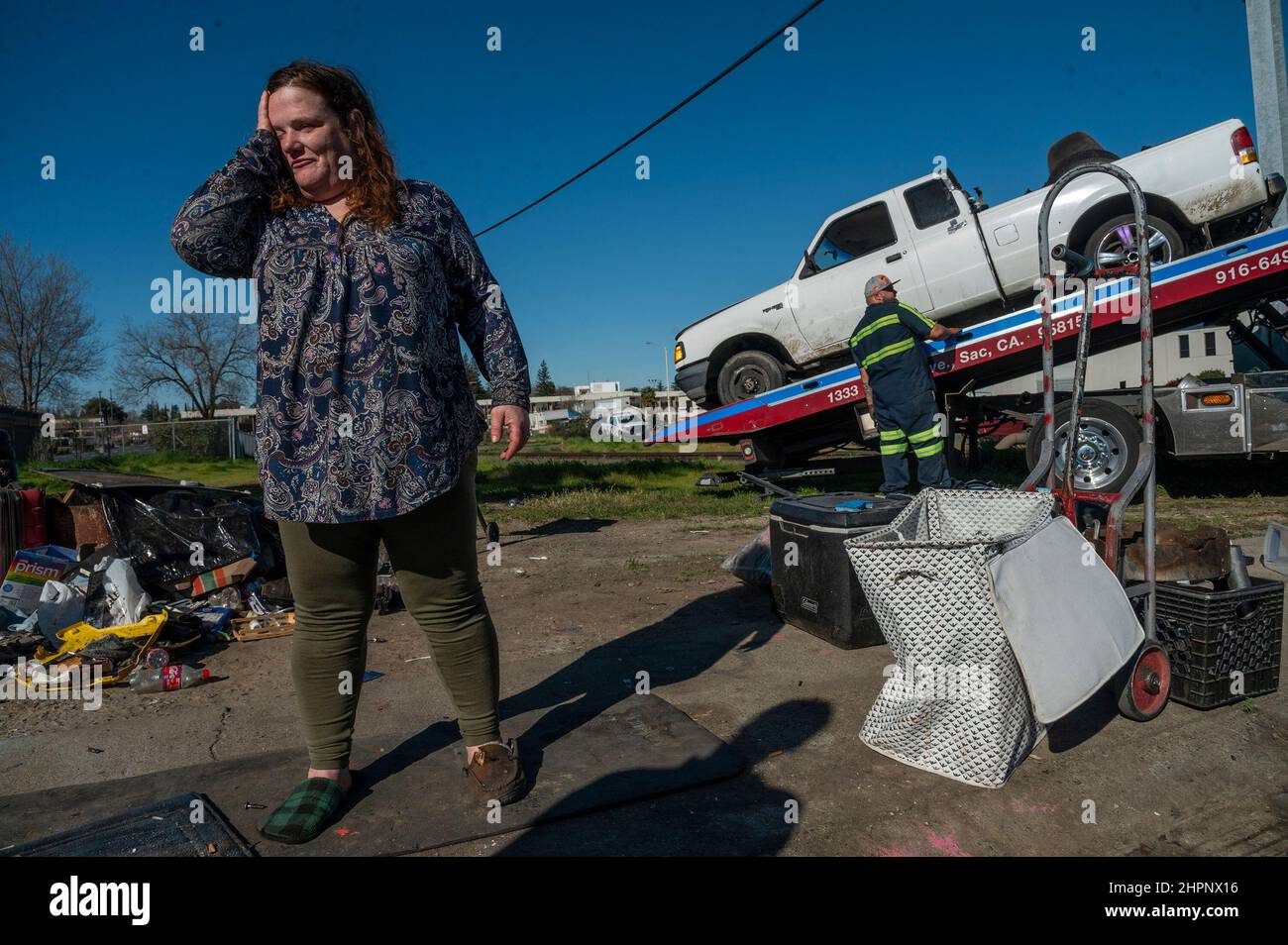 Sacramento, Calif, USA. 16th Feb, 2022. Danielle Chew, 43, reacts after her.nephew's trailer and pick up truck were towed from a homeless encampment along Evergreen Street in Sacramento on Wednesday, Feb. 16, 2022. 'I have an emergency housing voucher, I just can't find housing. We're trying my boyfriend has had a job for ten years,'' Chew said in tears. (Credit Image: © Renée C. Byer/ZUMA Press Wire) Stock Photo