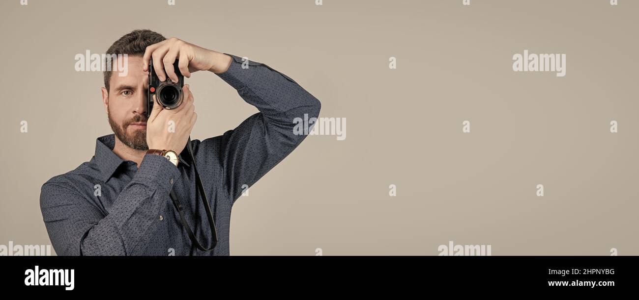 Amateur photographer shoot picture with handheld photo camera grey background, shooting Stock Photo