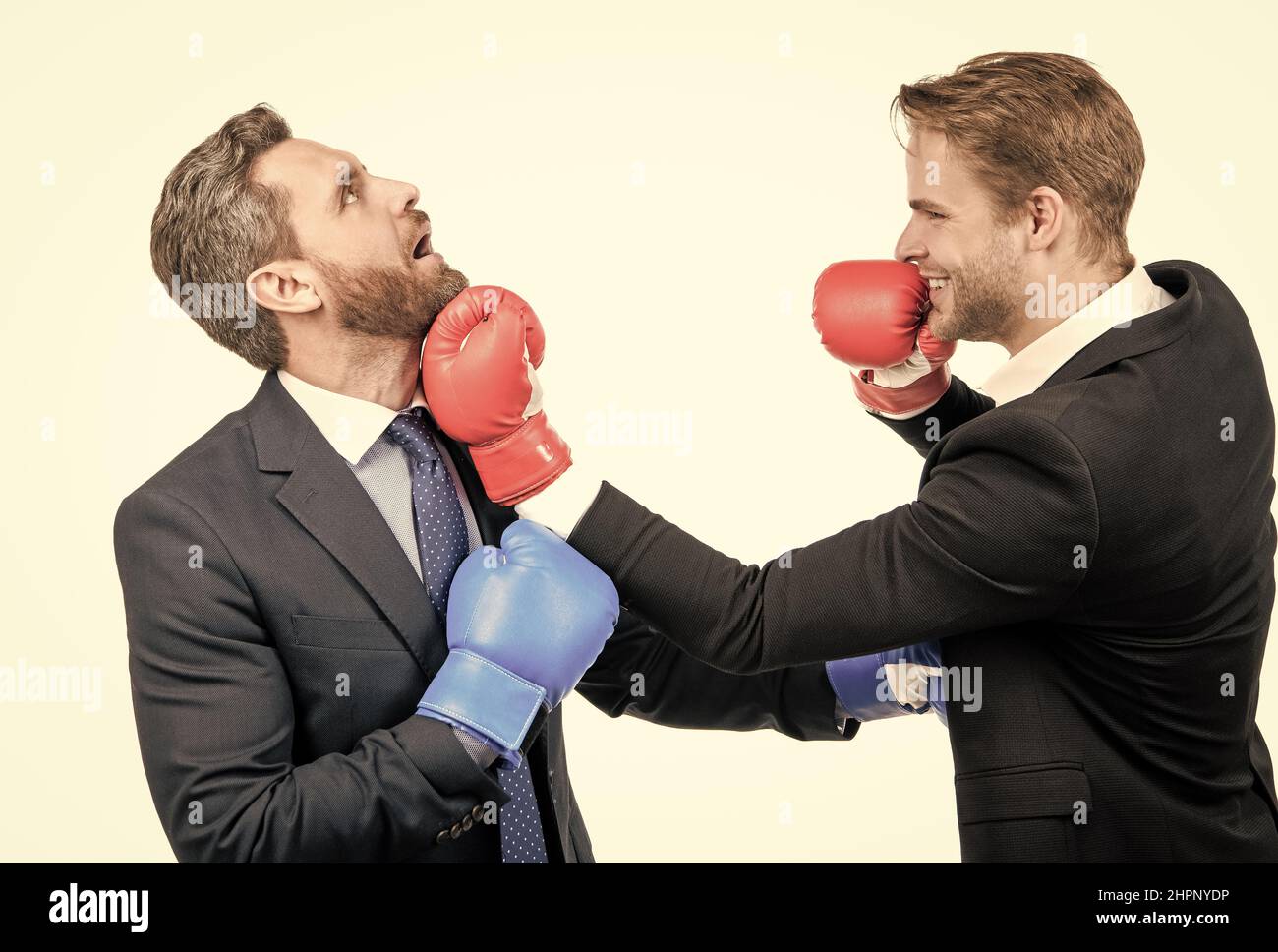 Business partners competitors fight with boxing gloves in formalwear isolated on white, competition Stock Photo