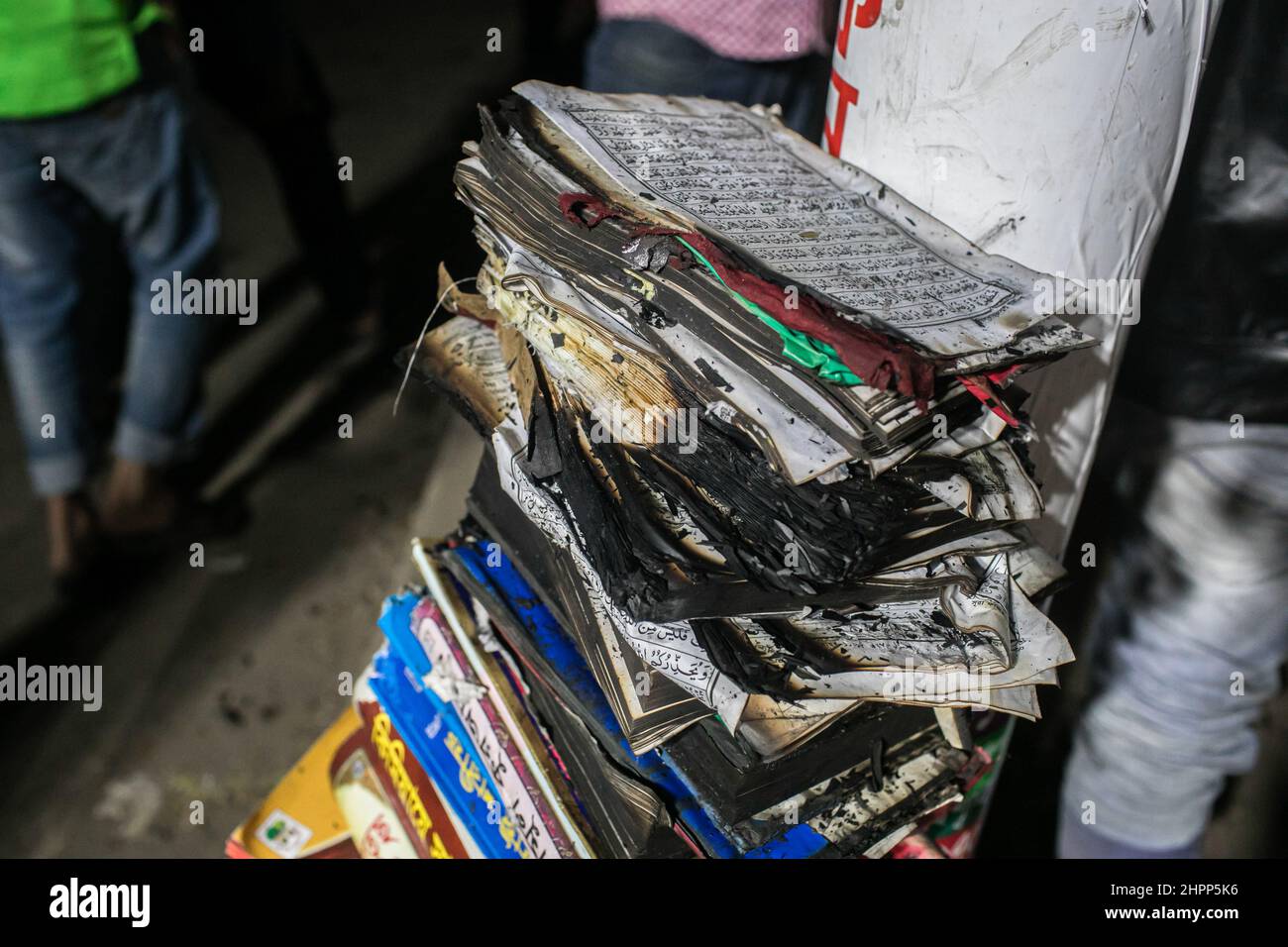 Dhaka, Bangladesh. 22nd Feb, 2022. View of burnt books around the scene of devastating fire that broke out at Book shops at the market in Nilkhet area of the capital on Tuesday afternoon. The fire originated from the book shops of Bakusha Hawkers Market around 7:47 pm. Abdul Halim, assistant director of Fire Service and Civil Defence Headquarters, confirmed that the fire that erupted, has been brought under control around 8:45 pm after two-hour long efforts of 10 firefighting units. Credit: SOPA Images Limited/Alamy Live News Stock Photo