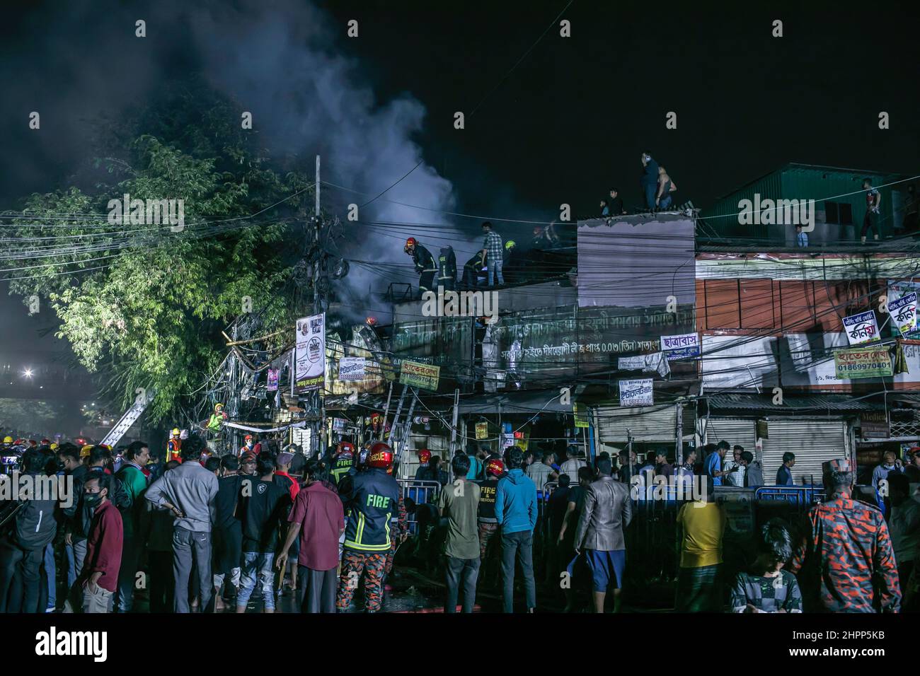 Dhaka, Bangladesh. 22nd Feb, 2022. View of people around the scene of devastating fire that broke out at Book shops at the market in Nilkhet area of the capital on Tuesday afternoon. The fire originated from the book shops of Bakusha Hawkers Market around 7:47 pm. Abdul Halim, assistant director of Fire Service and Civil Defence Headquarters, confirmed that the fire that erupted, has been brought under control around 8:45 pm after two-hour long efforts of 10 firefighting units. Credit: SOPA Images Limited/Alamy Live News Stock Photo
