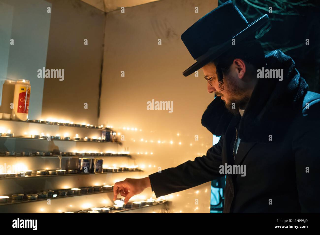 Lezajsk, Poland. 21st Feb, 2022. An ultra orthodox Jew (hassid) is seen lighting a candle. Every year ultra orthodox Jews come to Lezajsk (Poland) to visit the grave of Tzadik Elimelech to pray, dance and sing during his death anniversary. This is the traditional ceremony of Hassid Jews. They visit also the Jewish cemetery in Lancut, where Tzadiks Horowitz and Szapiro have graves. Credit: SOPA Images Limited/Alamy Live News Stock Photo