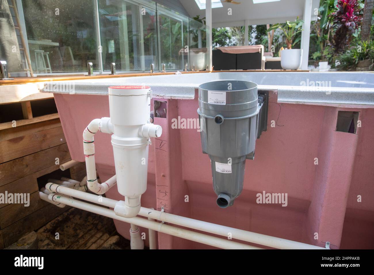 Fibreglass swimming pool in position with plastic plumbing pipework and filtration installed